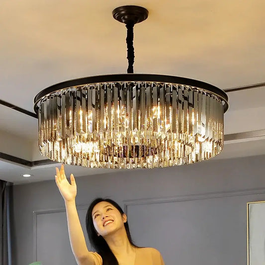 Modern black and gold pendant light with metal finish and cascading crystal prisms on a chain pendant for dining rooms