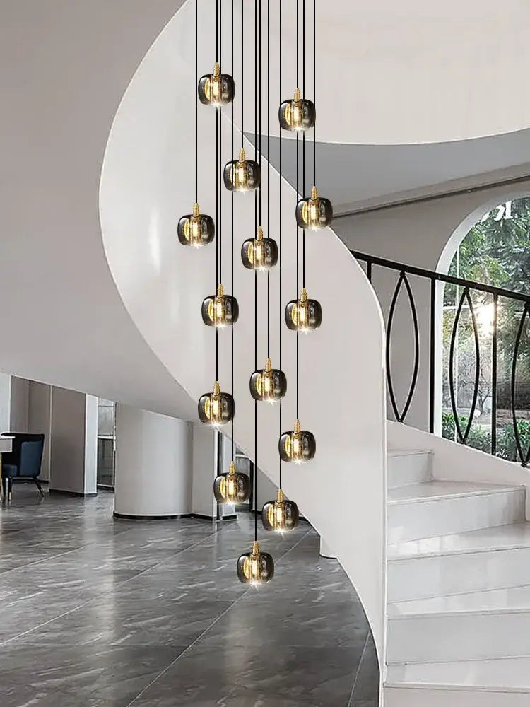 A modern black and gold crystal chandelier led pendant light with multiple spherical glass pendants for staircase use