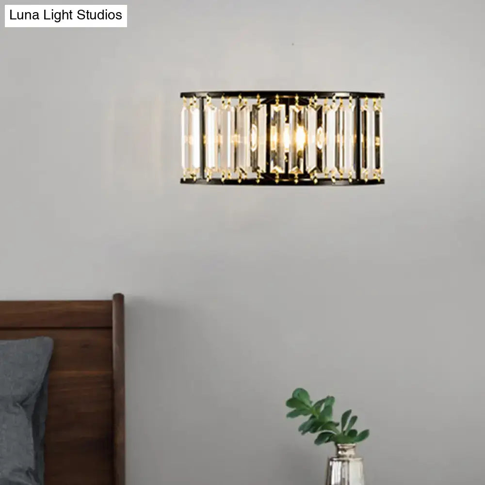 Modern black and gold crystal half cylinder wall sconce with clear crystal half rods emitting warm led glow for bedroom light