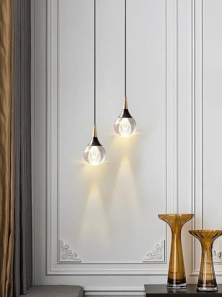Two modern black and gold decorbites crystal led teardrop pendant lights with brass accents for dining room lighting