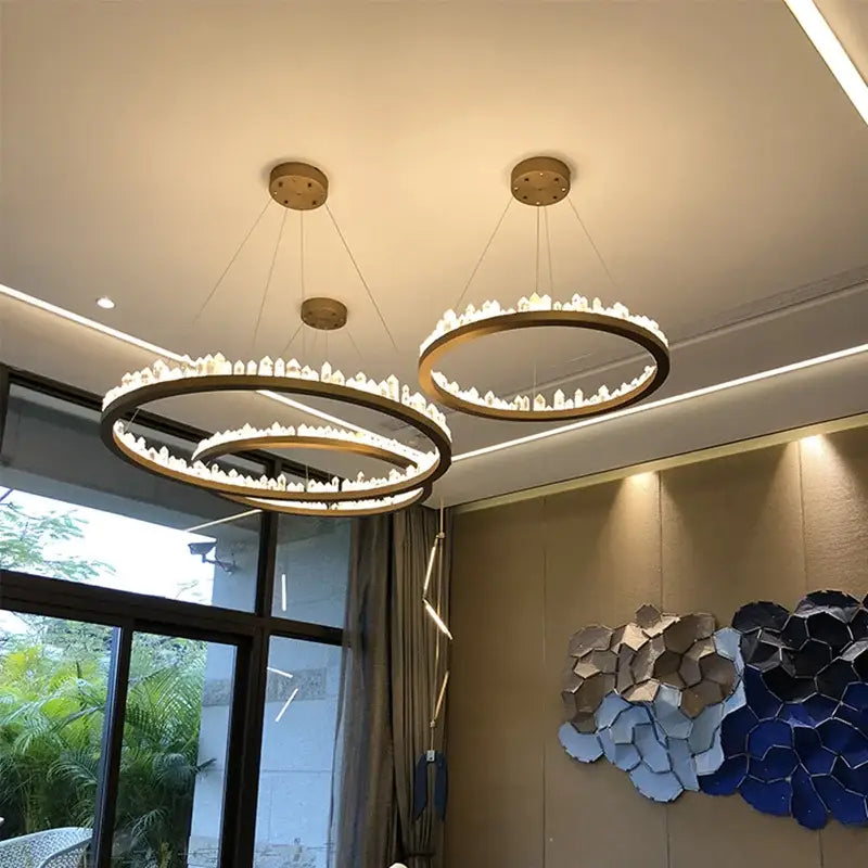 Modern black and gold crystal led pendant lights feature a gold-toned circular chandelier with embedded crystals