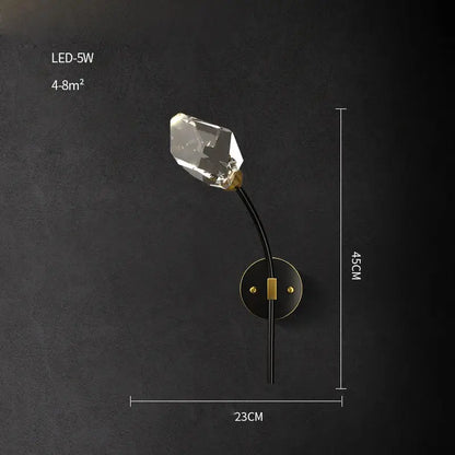 A sleek black and gold-toned decorbites crystal led wall sconce with a faceted clear bulb for modern bedroom lighting