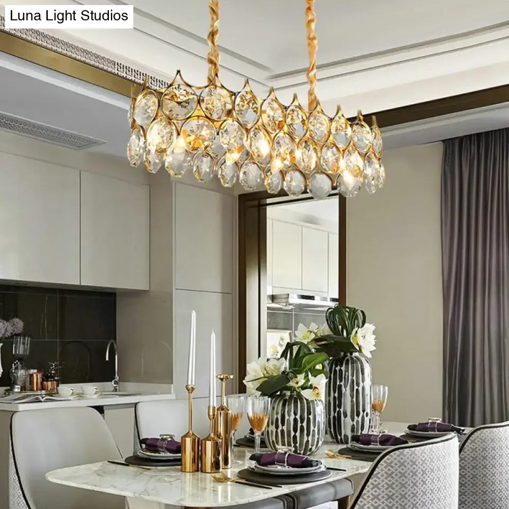Gold-toned pendant lighting fixture with crystal prism shade featuring dangling teardrop crystals for dining room
