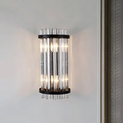Modern black and gold crystal rod cylinder wall sconce featuring vertical clear glass tubes framed by black metal rings
