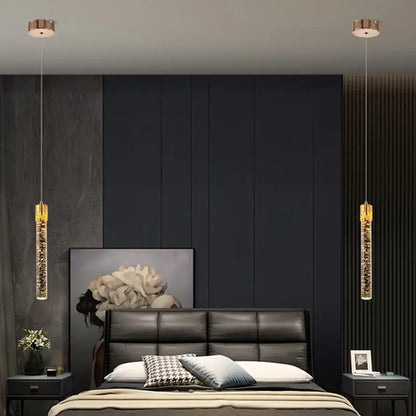 Two elegant gold-toned pendant lights with sparkling crystal rod interiors for modern dining room lighting
