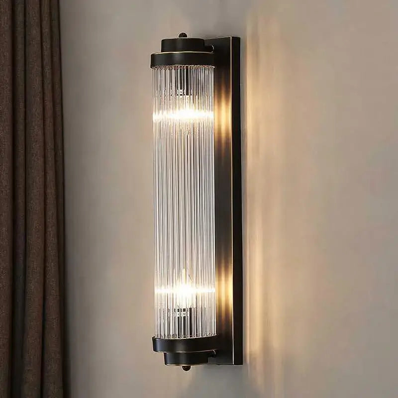 Modern black and gold crystal wall lamp with sleek metal frame and vertical glass rods diffusing warm light for living room