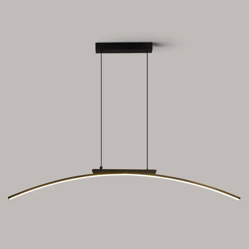 Modern black and gold curved bridge pendant light with sleek LED strip illuminating a dining table area