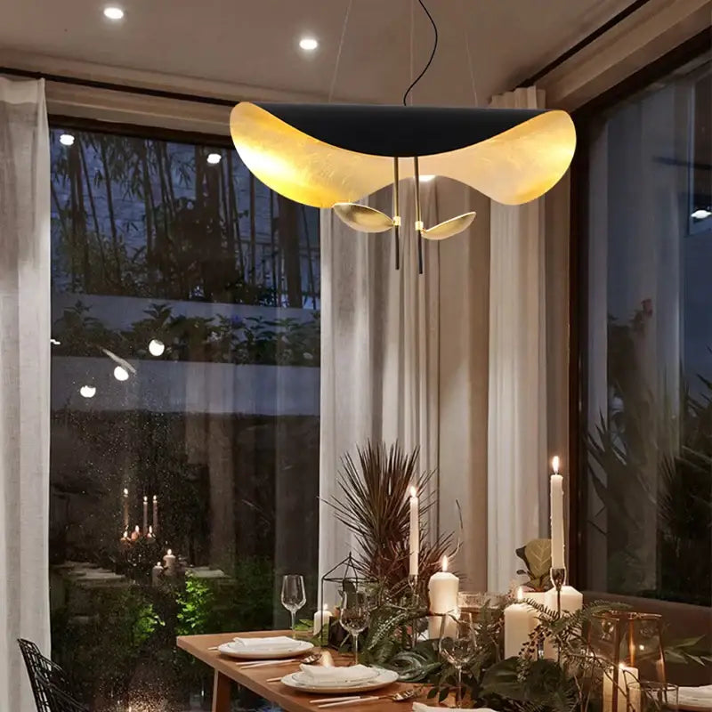 Modern black and gold curved lederam manta pendant light fixture hanging above dining table for elegant decorbites decor