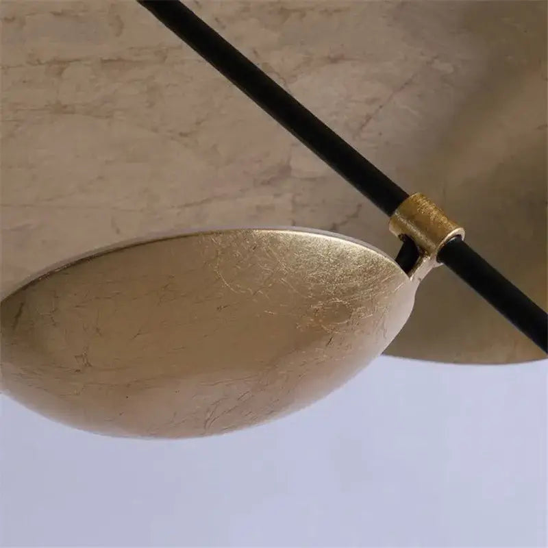 A sleek gold-toned metallic lederam manta pendant light with a smooth oval shade and black cable for dining room decorbites