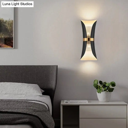 Modern black and gold curved wall lamp with sleek design ideal for bedroom lighting and decor