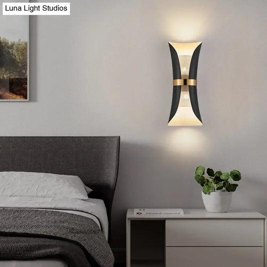 Modern black and gold curved wall lamp with sleek design ideal for bedroom lighting and decor