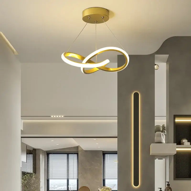 Gold-colored led ceiling light with two interlocking rings in a decorbites contemporary chandelier for dining room