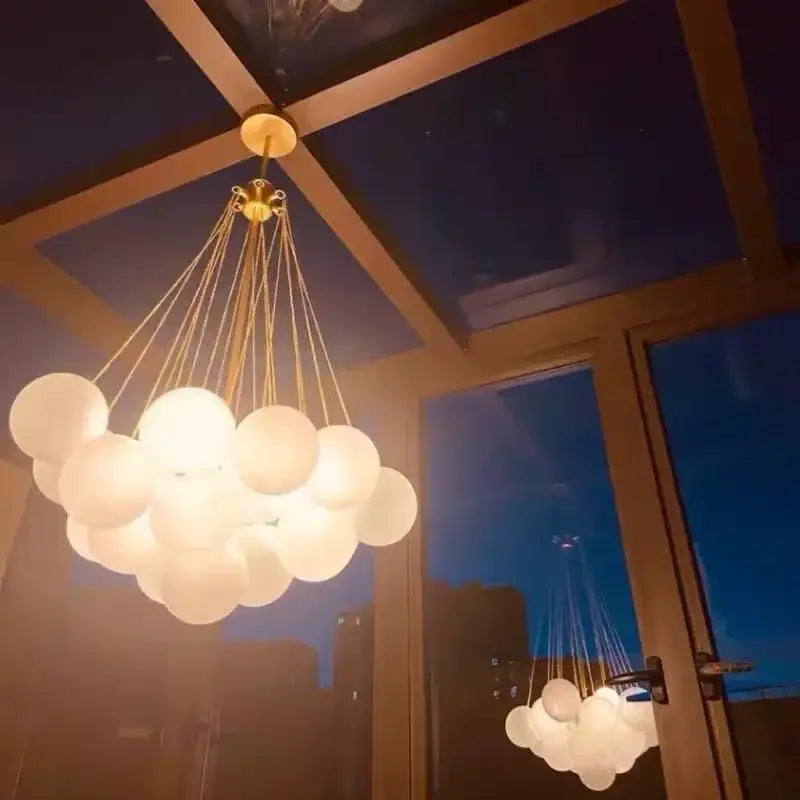 Modern black and gold decorbites glass chandelier with frosted glass spheres and brass fixture for dining room lighting