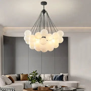 Modern black and gold decorbites glass chandelier with frosted glass spheres on metal arms for dining room lighting