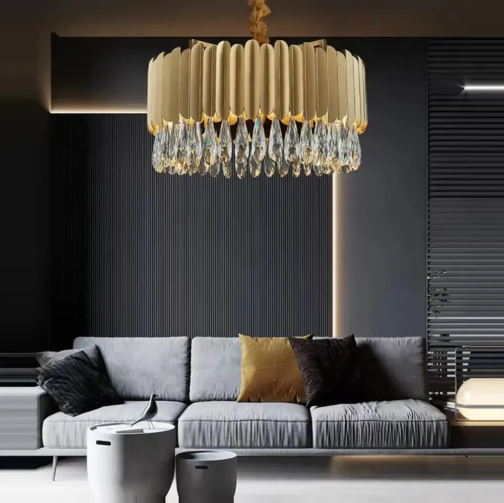 A modern gold-toned dimmable led round ceiling chandelier with ribbed design and decorbites crystal teardrop pendants