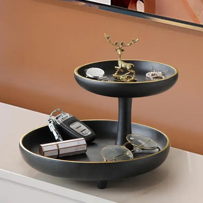 Modern black and gold two-tiered coffee table tray with gold rim and golden deer figurine for living room storage