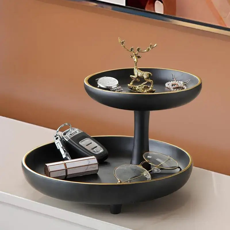 Modern black and gold two-tiered coffee table tray with gold rim and golden deer figurine for living room storage