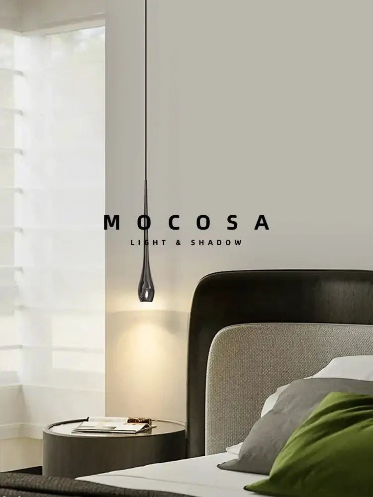 A sleek modern black and gold pendant light with metallic finish and remote control hanging in a dining room