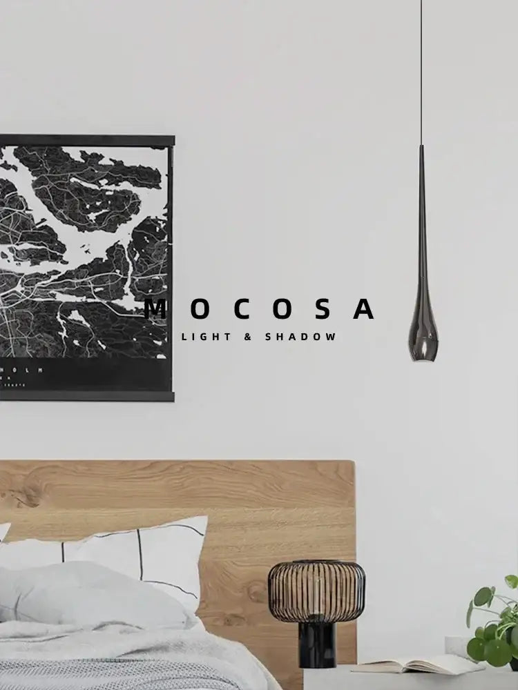 A sleek dark gray pendant light with metallic finish and remote control hangs in a modern dining room setting