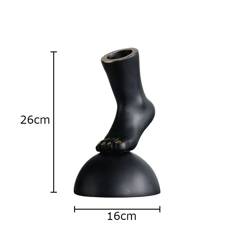 Modern black resin foot statue artwork with hollowed top on rounded base for living room decor
