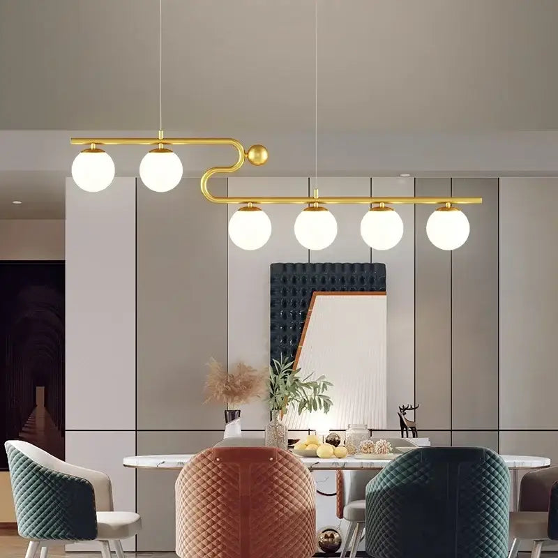 Modern black and gold chandelier pendant with five white glass ball led bulbs on a sleek curved metal arm by decorbites