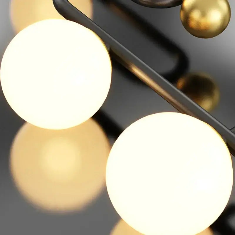 Modern black and gold chandelier pendant with frosted glass ball led shades and polished brass accents for dining room decorbites