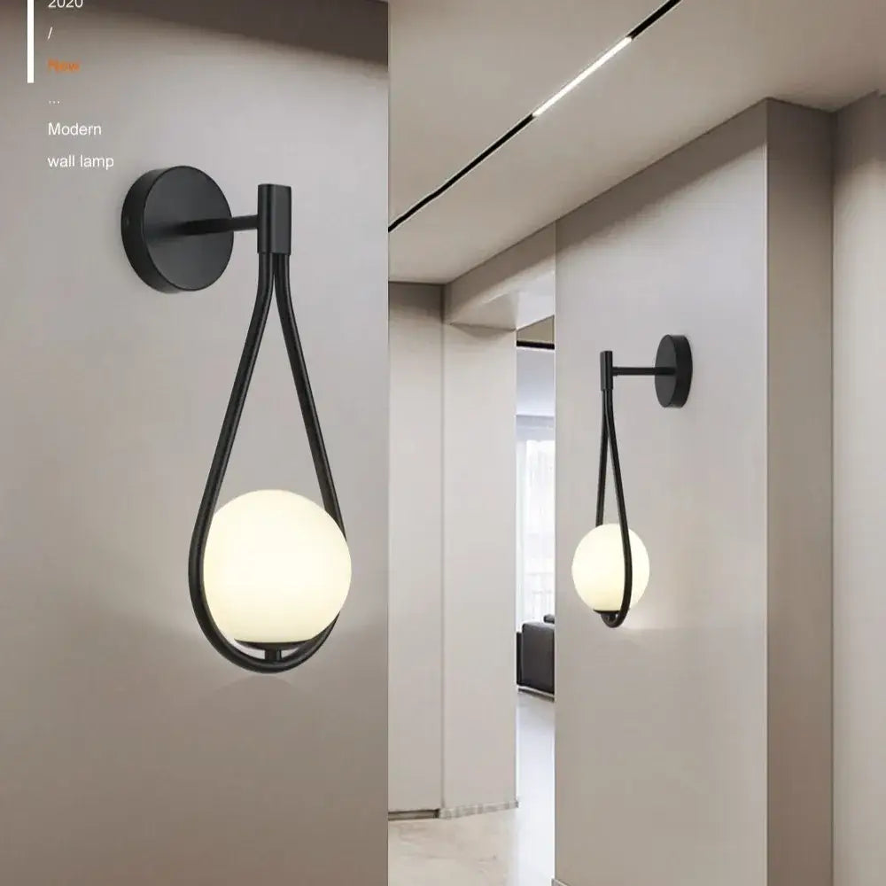Modern black and gold decorbites glass ball led wall lamp with a sleek teardrop frame and frosted glass globe for bedroom decor