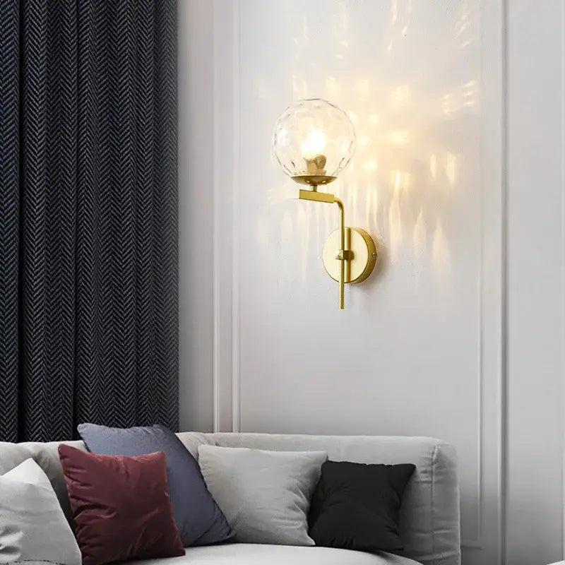 Modern black and gold wall lamp featuring a gold-toned sconce with a clear faceted decorbites glass ball led globe