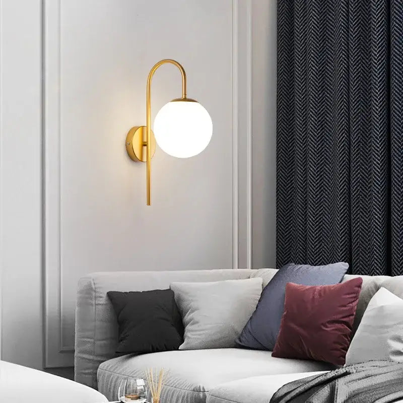 Modern black and gold decorbites glass ball led wall sconce with curved arm and frosted glass shade for bedroom decor