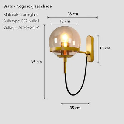 Modern black and gold brass wall sconce lamps with a spherical cognac glass shade for bedroom lighting