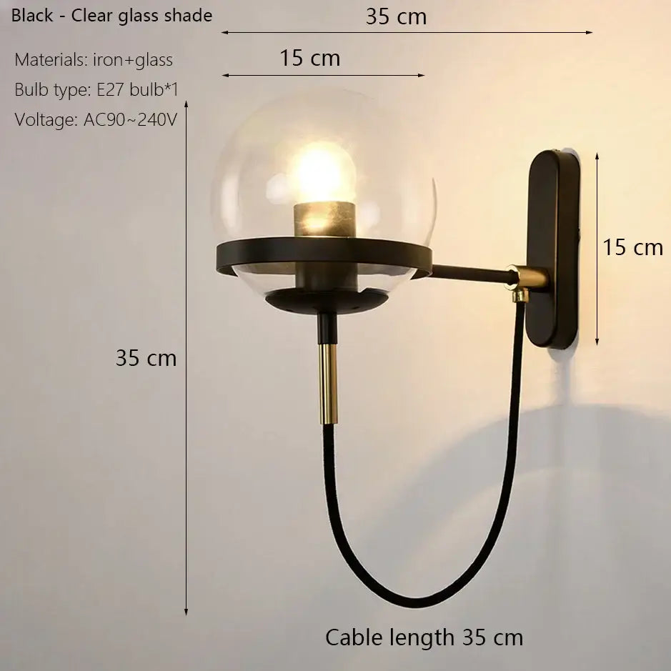 Modern black and gold glass globe wall sconce featuring a black wrought iron frame with brass accents for bedroom lighting wall sconce lamps