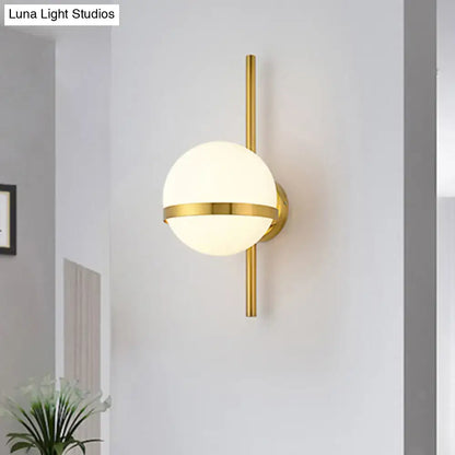 Modern black gold glass shade wall sconce featuring a gold-toned spherical frosted glass globe and minimalist vertical rod