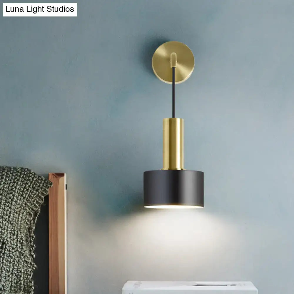 Modern black and gold grenade shaped wall lamp with brushed gold base and black cylindrical shade for bedroom reading light