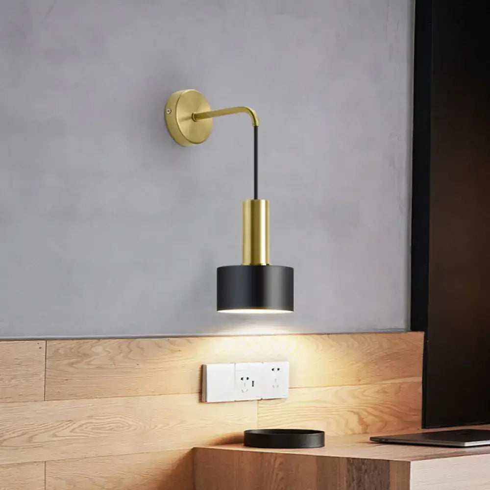 Modern black and gold grenade shaped wall lamp with a curved arm and cylindrical shade for bedroom reading light