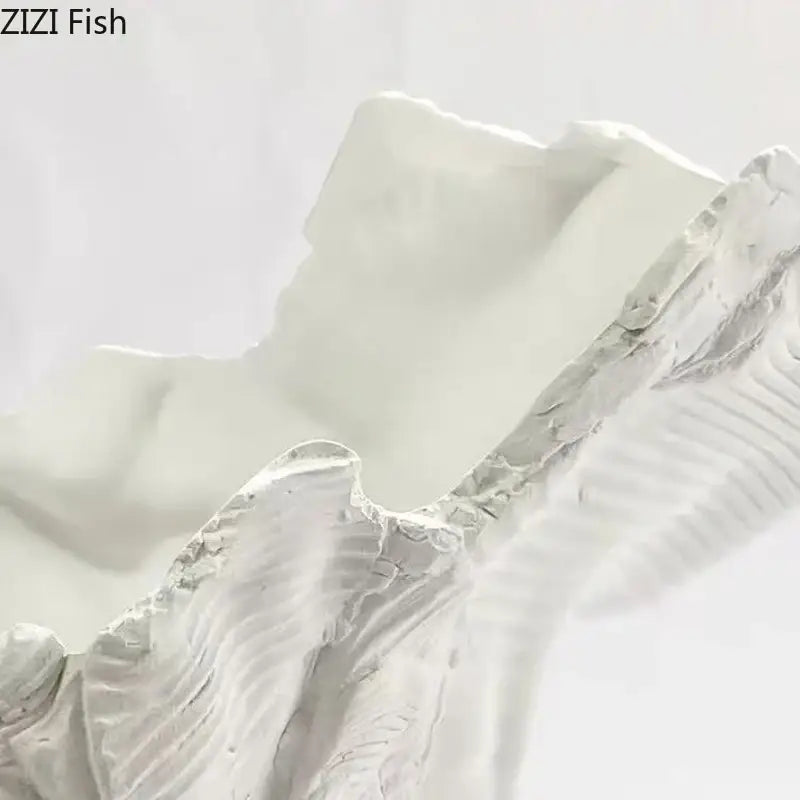 White sculptural shell centerpiece with textured ridged surface and smooth interior as decorbites irregular shape vase decor