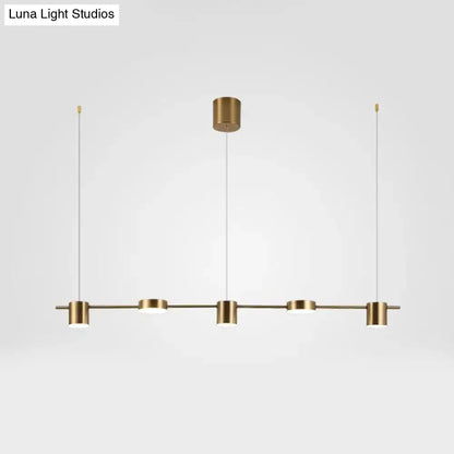 Modern black gold ceiling light fixture with brass finish and four cylindrical pendant lights for kitchen island lighting