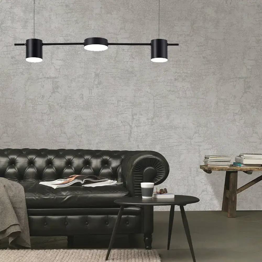 Modern black gold ceiling light fixture with three black cylindrical pendant bulbs on a sleek horizontal bar