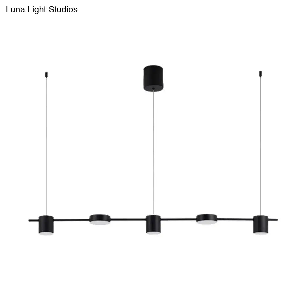 Modern black and gold ceiling light fixture with five black cylindrical LED pendants suspended by thin cables
