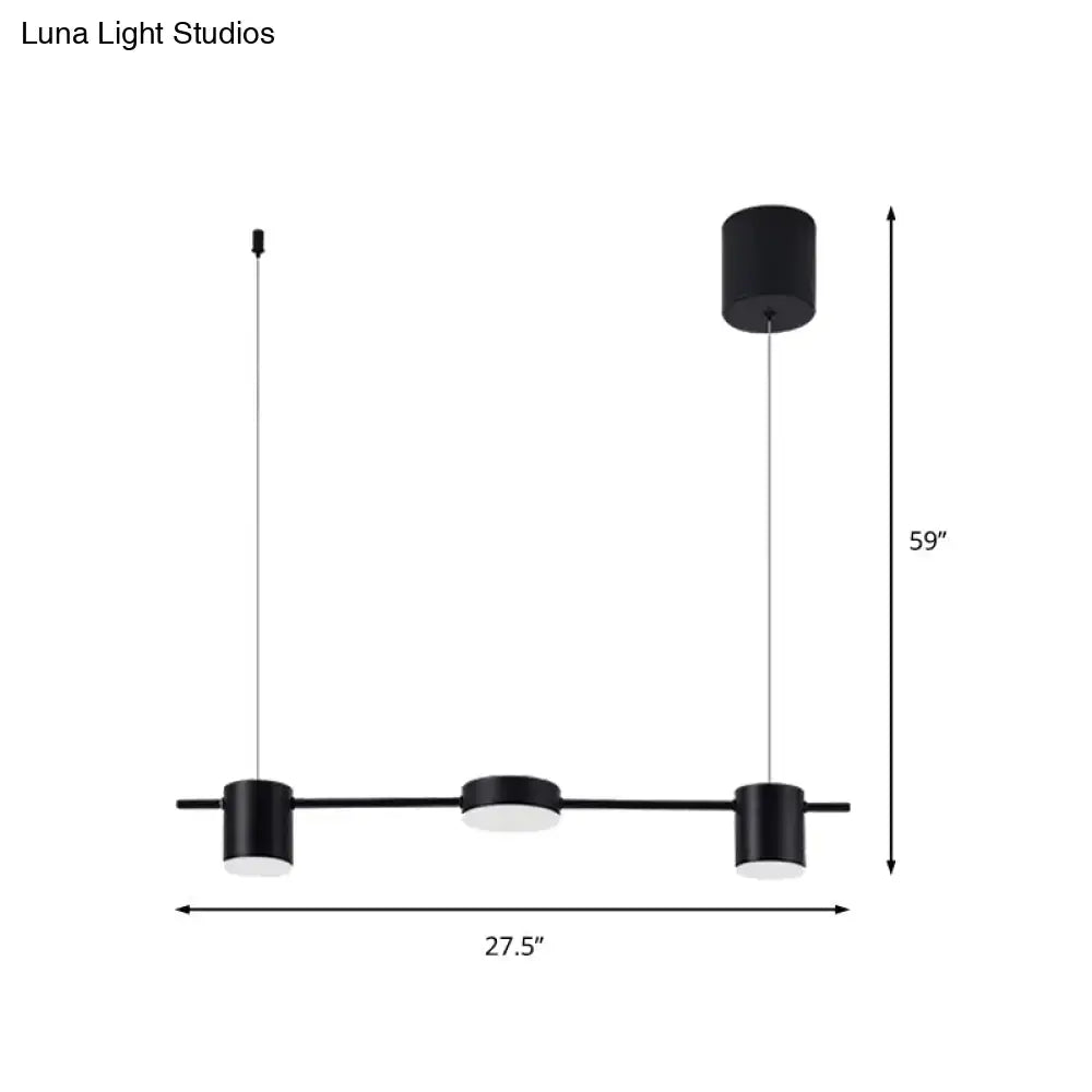 Modern black and gold light fixture with three matte black cylindrical pendant ceiling lights for kitchen island