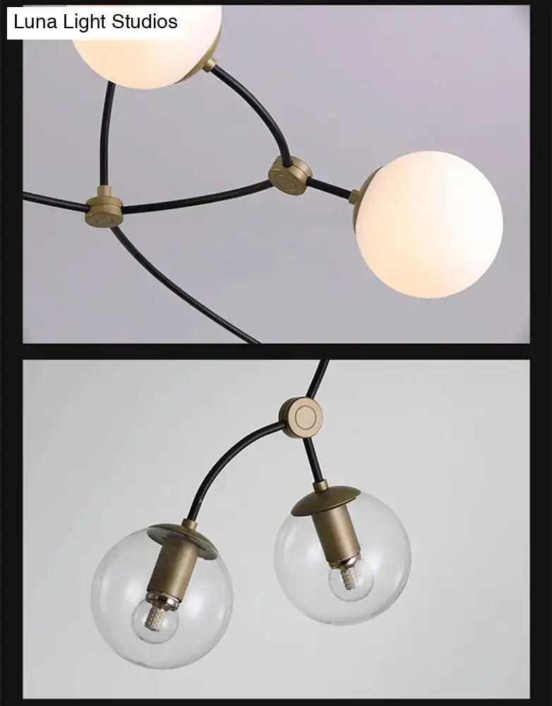 Modern black and gold island light with brass finish black curved arms and ball glass shade for dining room use