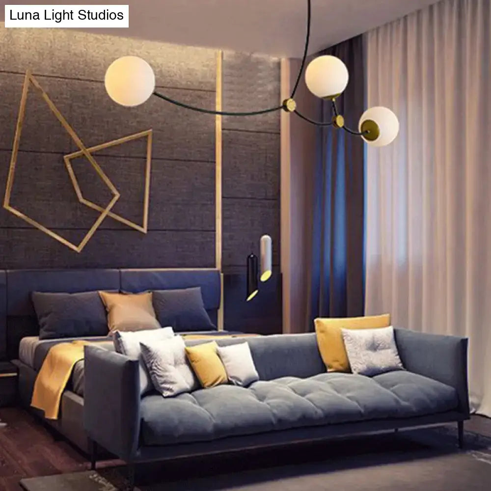 Modern navy blue tufted sofa with gold and white accent pillows displayed near black and gold island light with ball glass shade