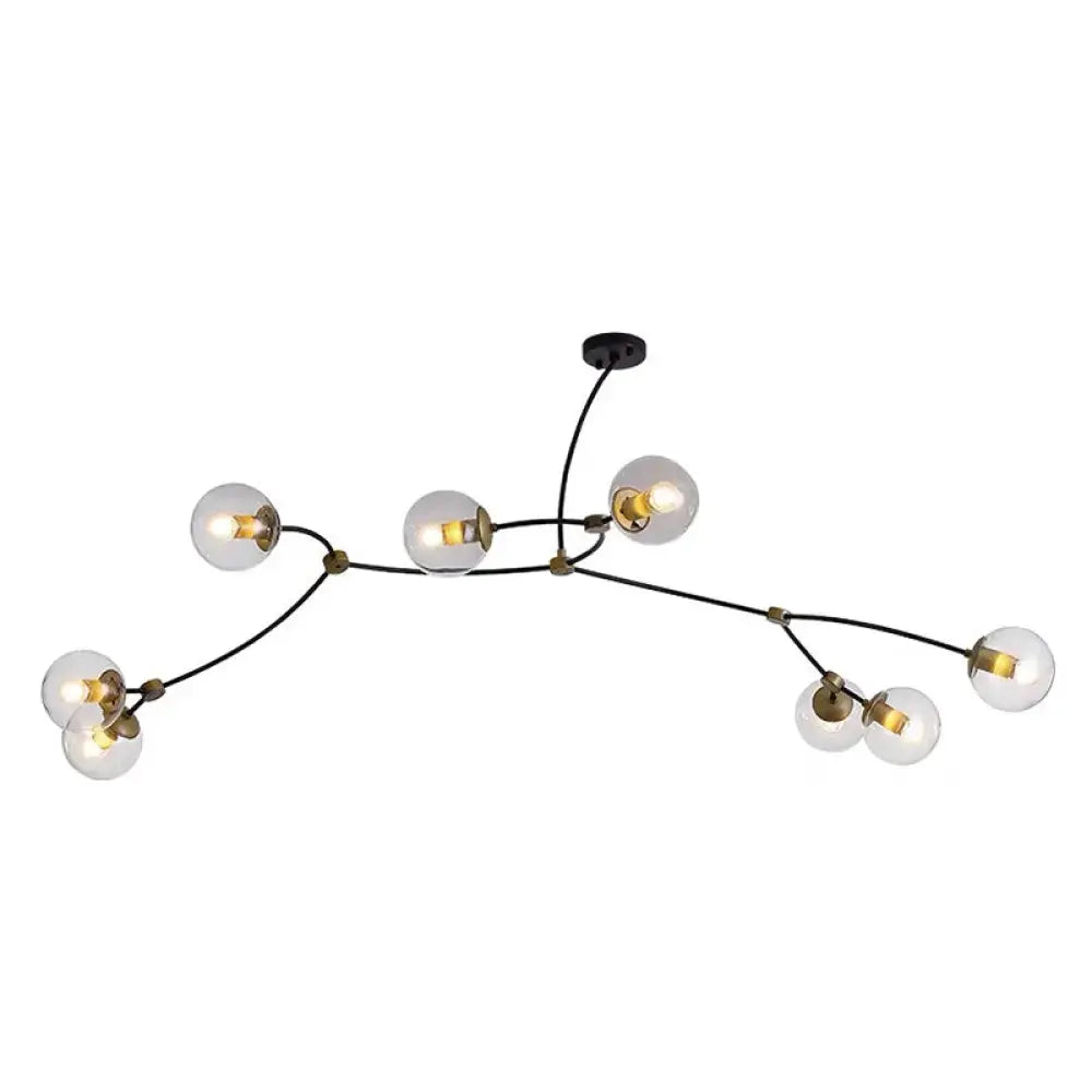 Modern black and brass branch-style island light with ball glass shade featuring clear glass globe bulbs for dining room