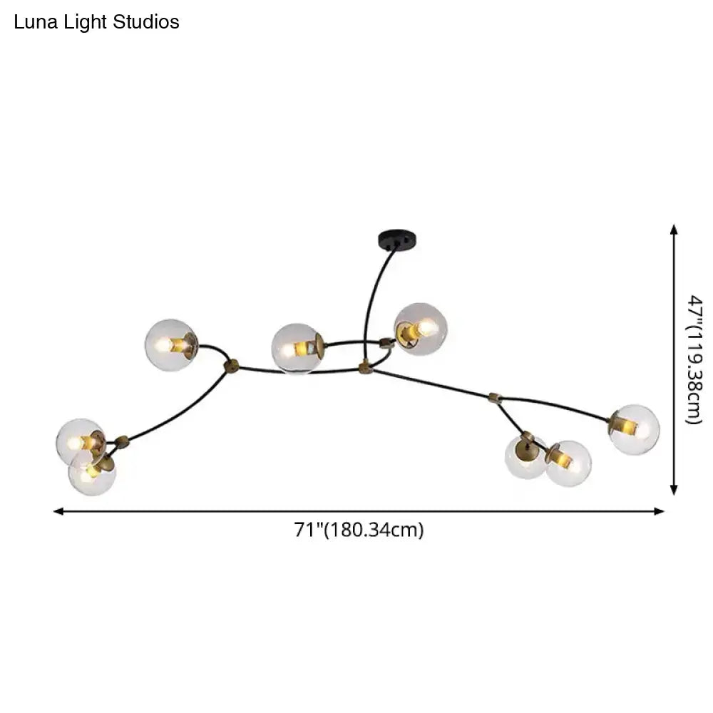Modern black and gold island light featuring black metal and brass accents with seven clear ball glass shade bulbs for dining room