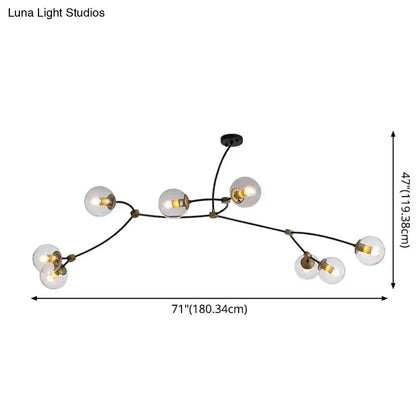 Modern black and gold island light featuring black metal and brass accents with seven clear ball glass shade bulbs for dining room