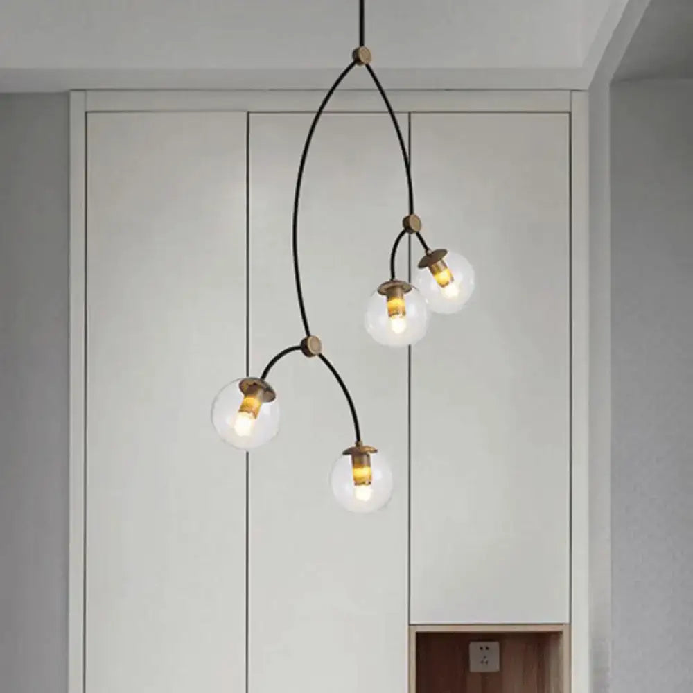 Modern black and gold island light with ball glass shade featuring four clear glass globe bulbs and brass fixtures for dining room