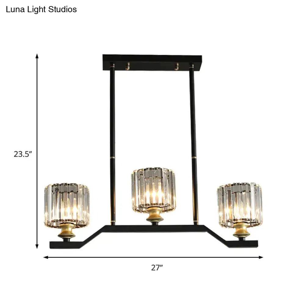 Black metal island pendant light with three clear crystal cylinder barrel shade candle-style lights and gold accents