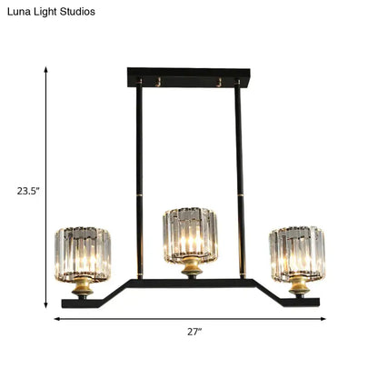 Black metal island pendant light with three clear crystal cylinder barrel shade candle-style lights and gold accents