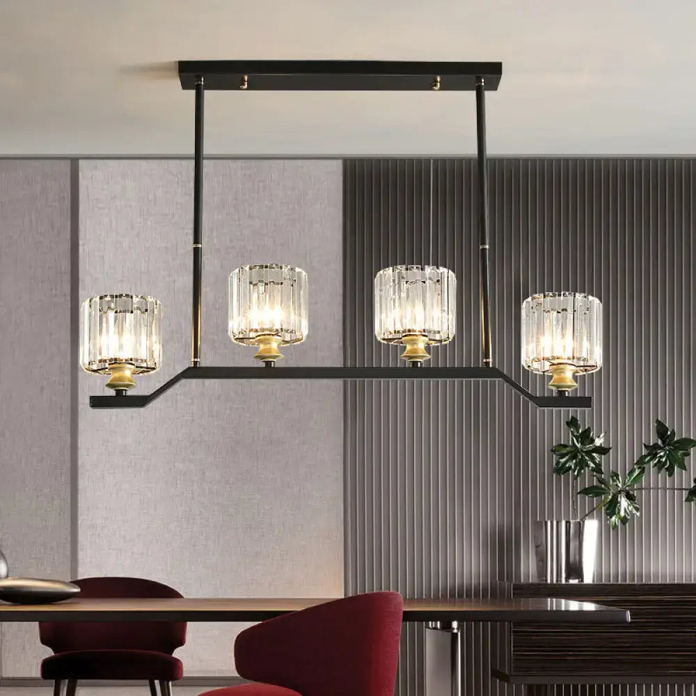 Black metal island pendant light with four clear crystal cylinder barrel shades and gold-toned accents for indoor use