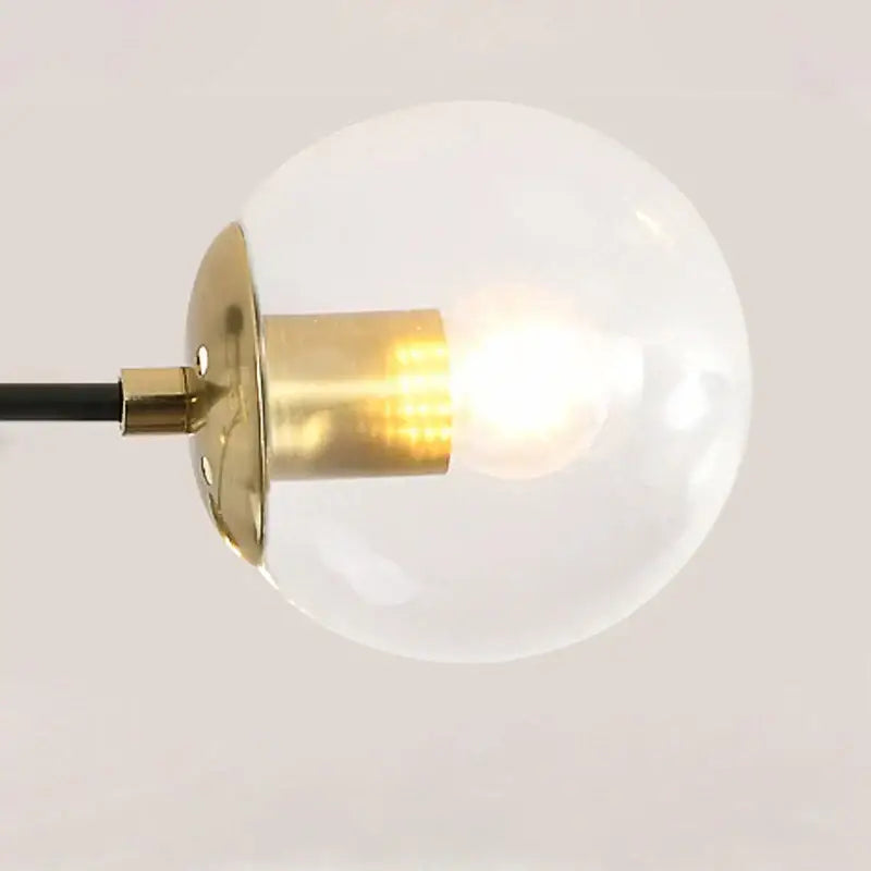 Modern black and gold led chandelier with a glowing glass globe pendant light and brass finish by decorbites black