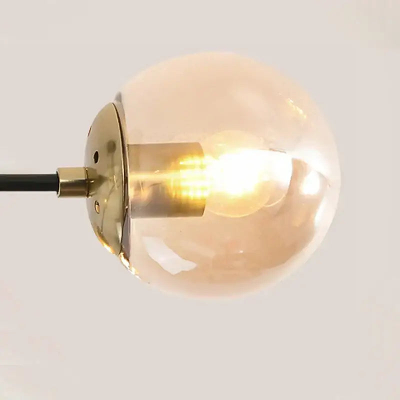 Modern black and gold led chandelier featuring a warm-toned glass globe pendant light with brass hardware and visible filament bulb decorbites black gold led chandelier